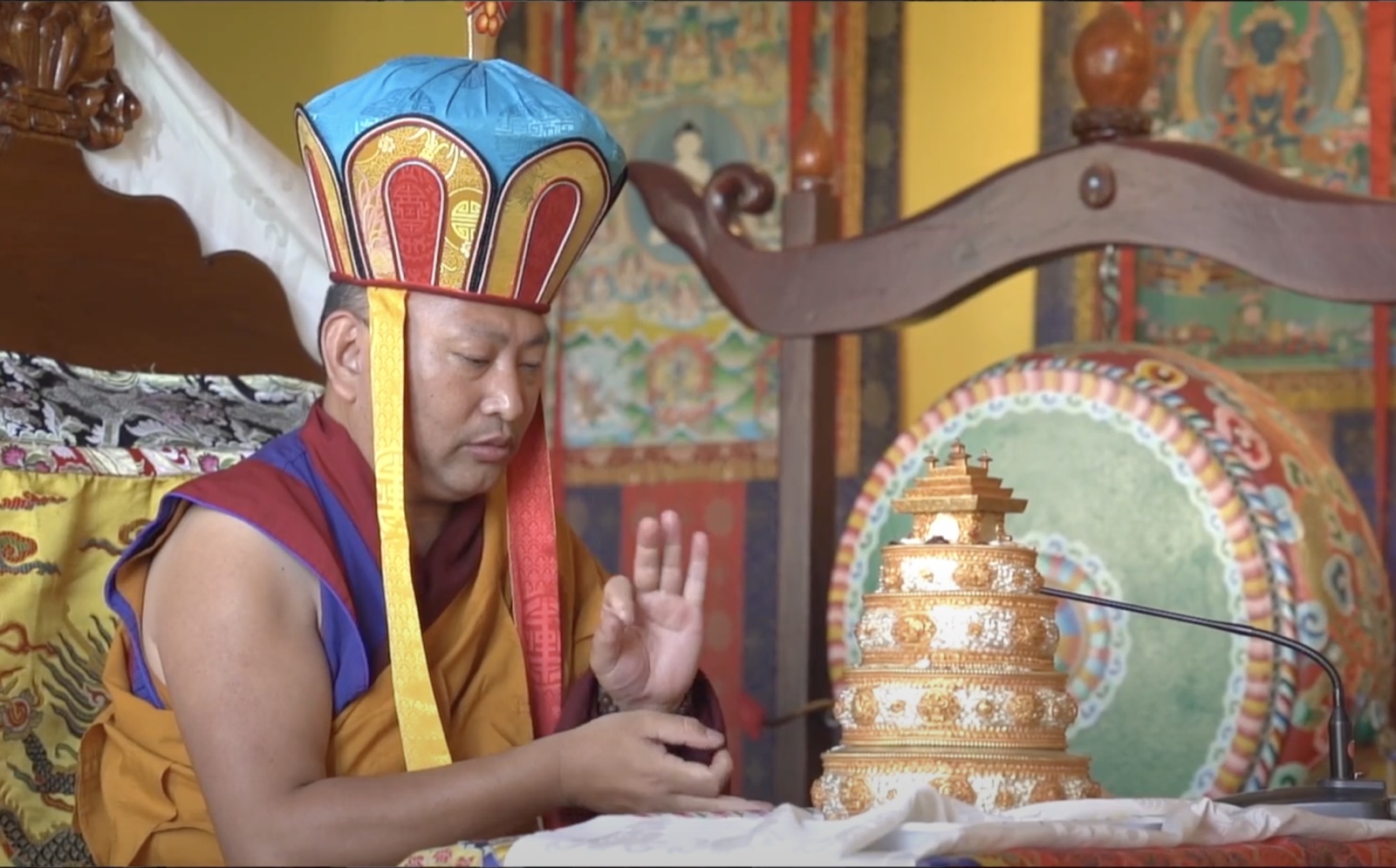 A master teaching, beside a mandala offering